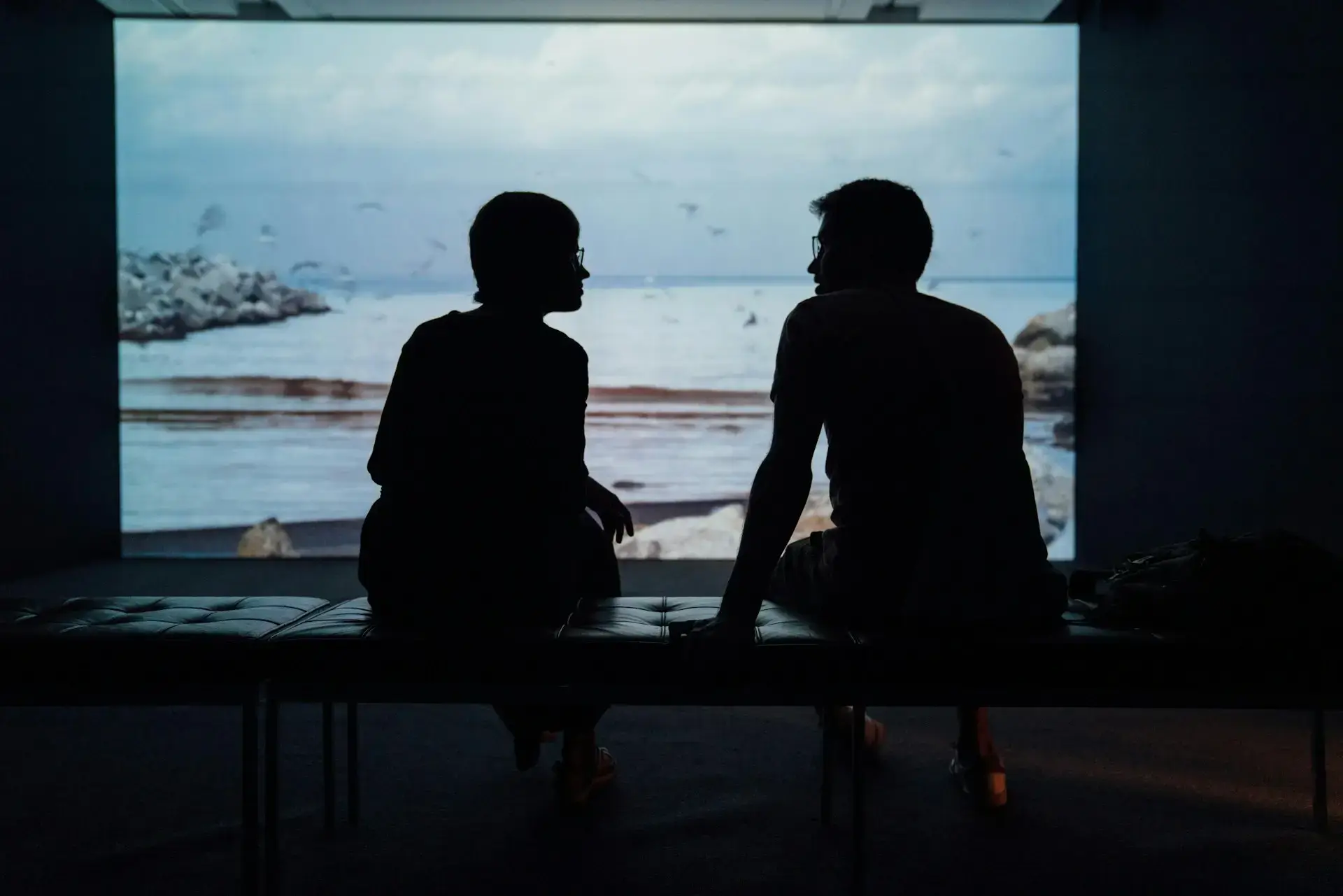 Two people talking looking out at water